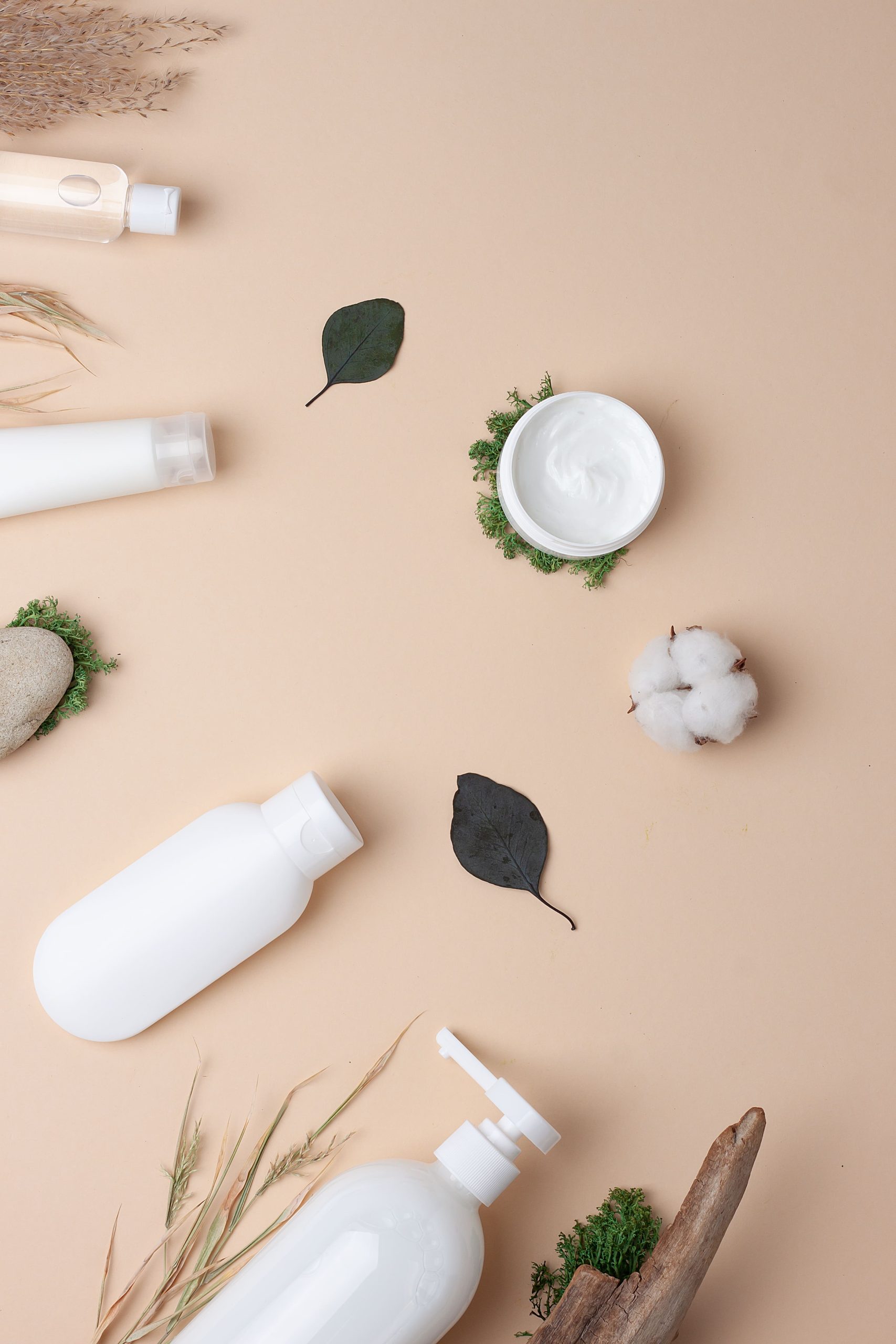Productos cosméticos y capilares en envases minimalistas sobre fondo neutro